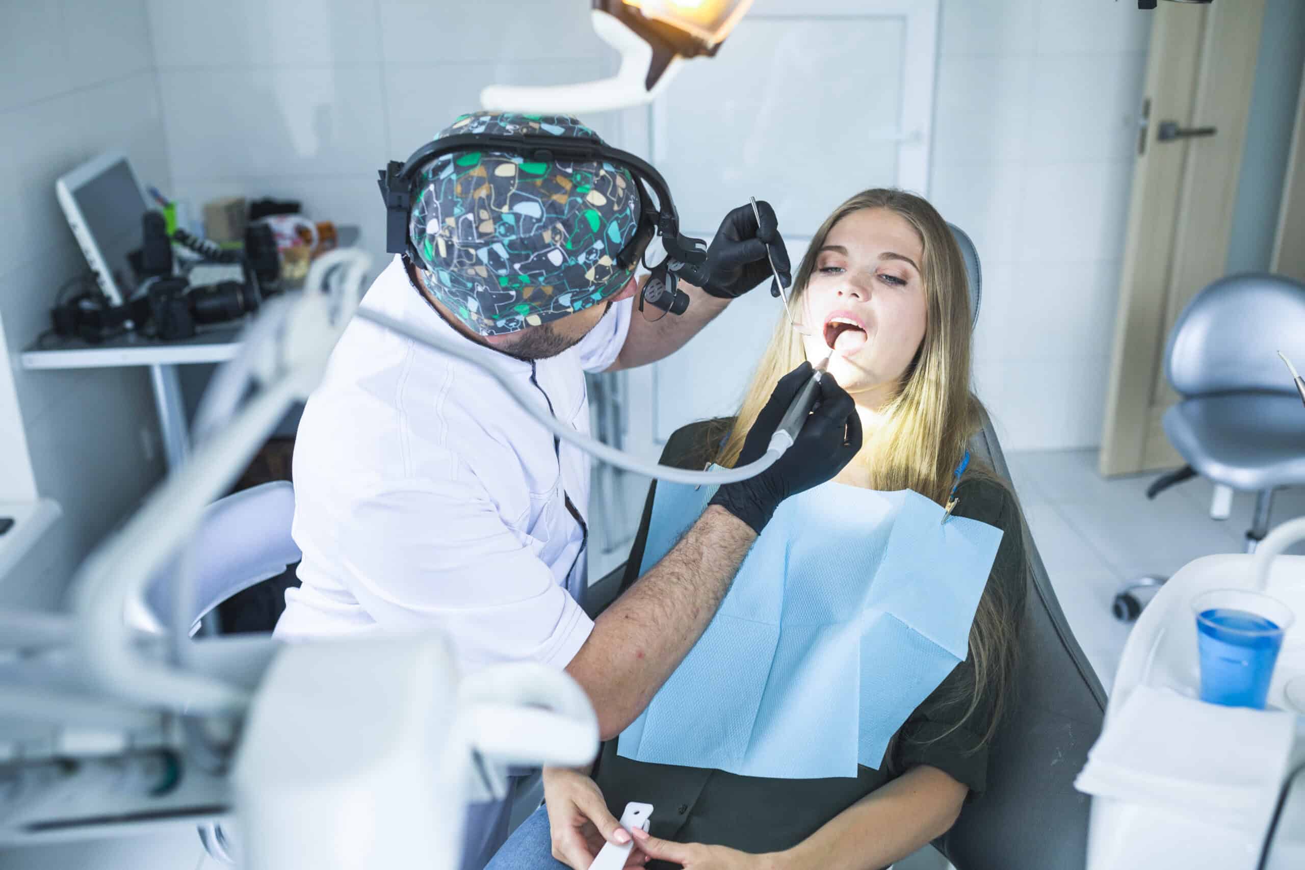 dentist is doing root canal treatment of a young female patient