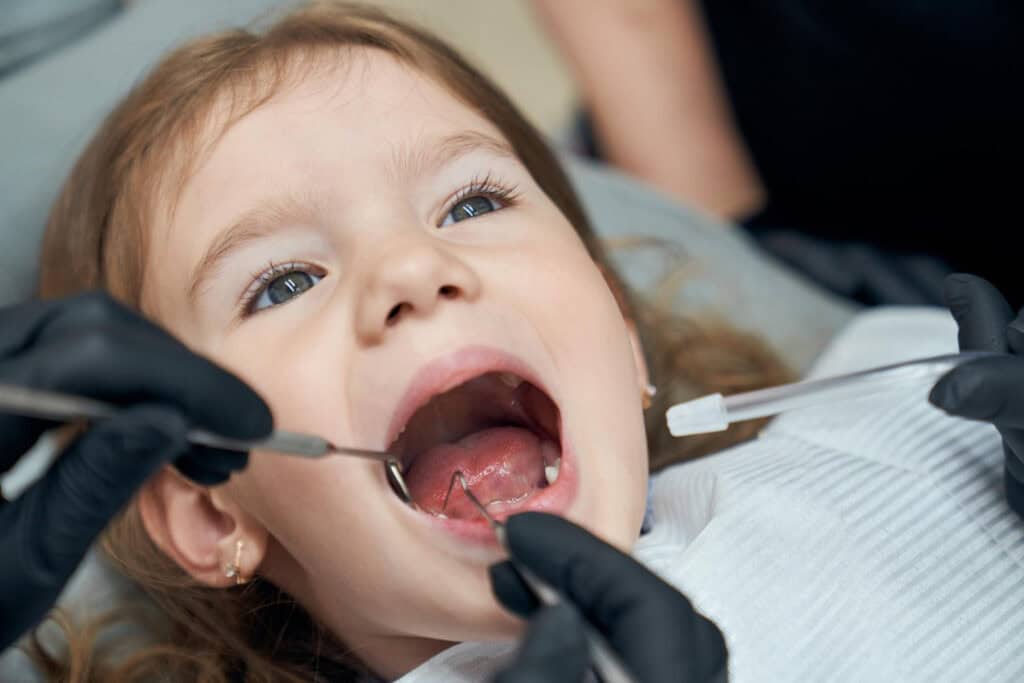 Pediatric dentist examining a young child’s teeth during a dental checkup in Great Neck, NY.