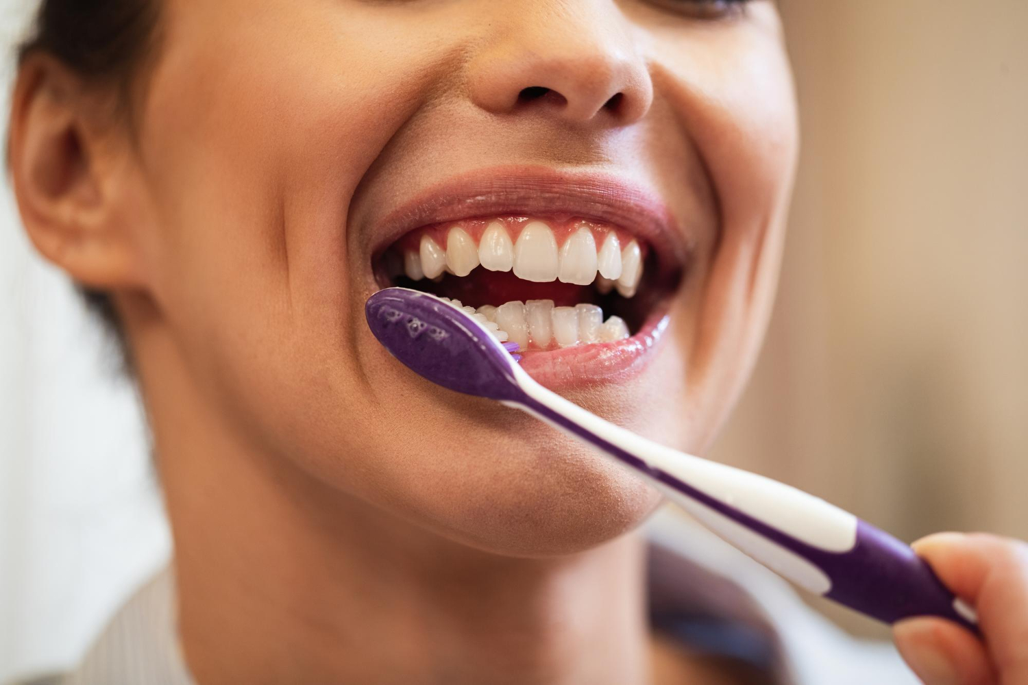 Woman brushing teeth for oral hygiene, showing dental care, healthy teeth, and gum health as part of daily routine.