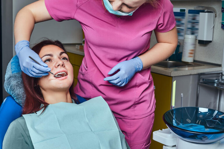 Dentist examining a patient during a root canal in Great Neck, showing a close-up view of dental treatment underway NY now.