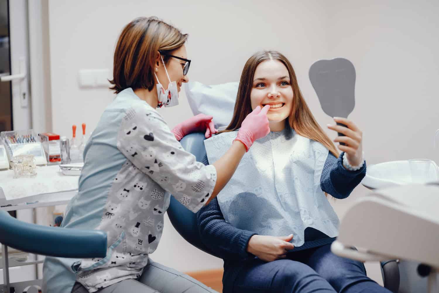 Dentist examining a patient's teeth during a dental consultation before starting Invisalign and teeth whitening treatment