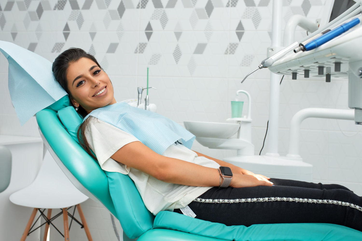 Patient relaxing in a dental chair during root canal recovery while receiving comfortable dental care from the dentist.