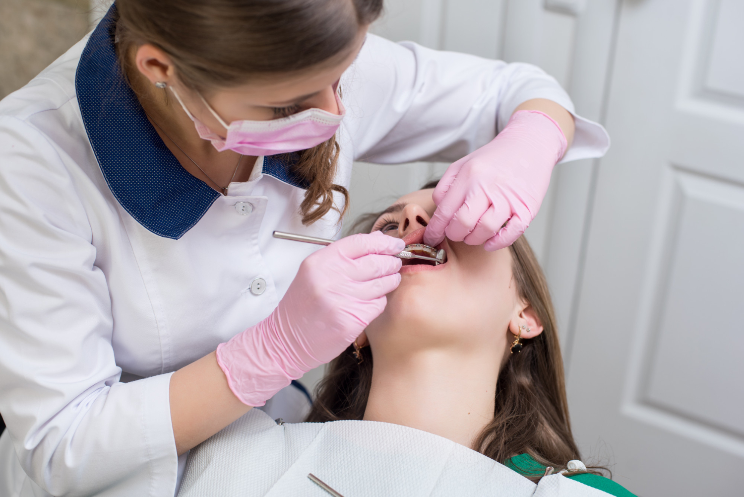 Dentist performing root canal treatment on a patient in a dental office during a step-by-step endodontic procedure today.