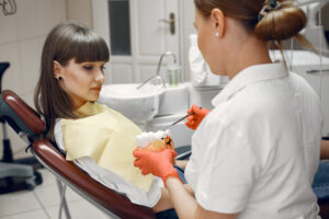Dentist examining a patient during a root canal recovery consultation and checking the treated tooth in a dental clinic.