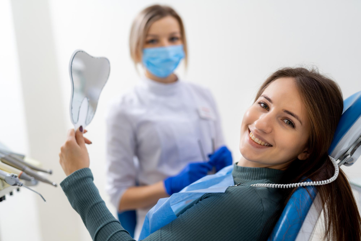 Dentist examining a smiling patient during a routine dental checkup in a modern clinic.