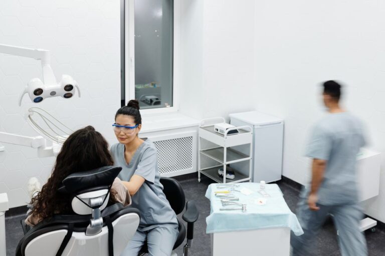 Dentist providing dental treatment to a patient in a modern clinic, showing professional dental care in Great Neck, NY.