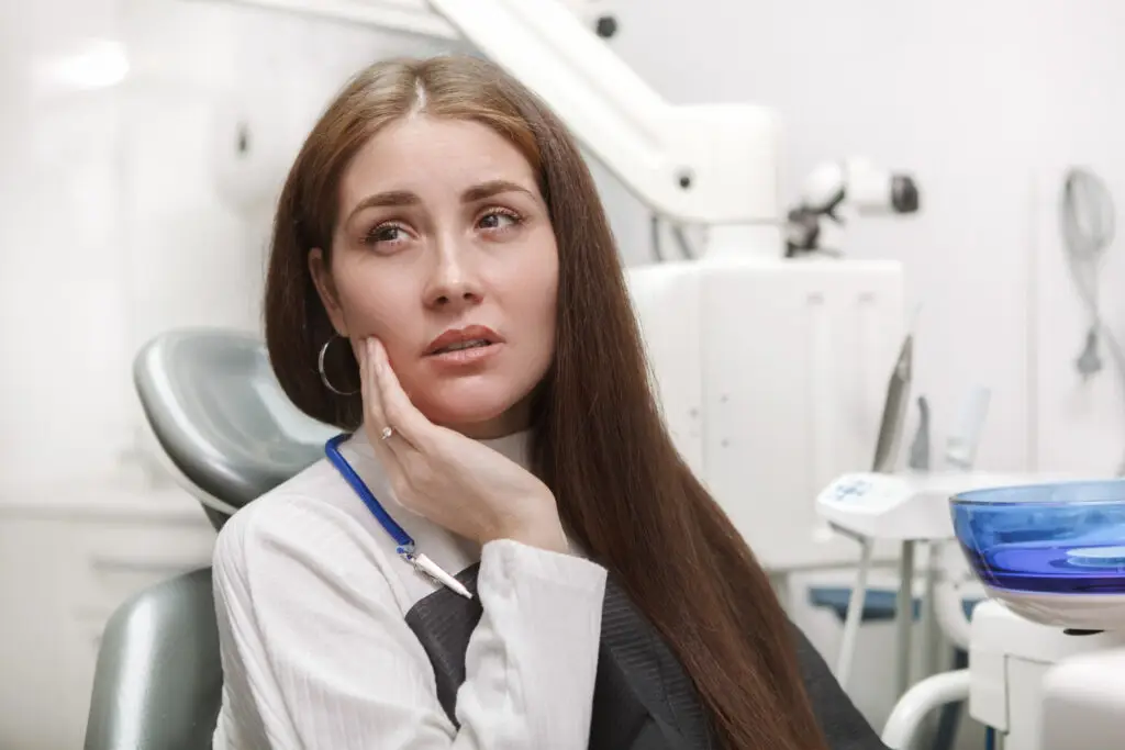 Tooth extraction patient experiencing tooth pain in a dental clinic in Great Neck, NY.