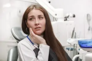Tooth extraction patient experiencing tooth pain in a dental clinic in Great Neck, NY.