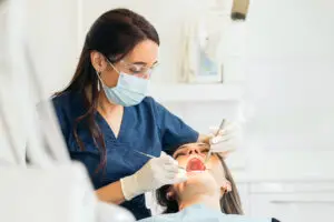 Dentist performing oral surgery treatment on a patient in a dental clinic in Great Neck, NY